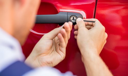 Close-up Of Person's Hand Opening Car Door With Lockpicker